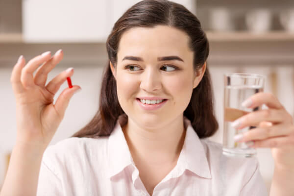 women with Duromine weight loss tablent and glass of water
